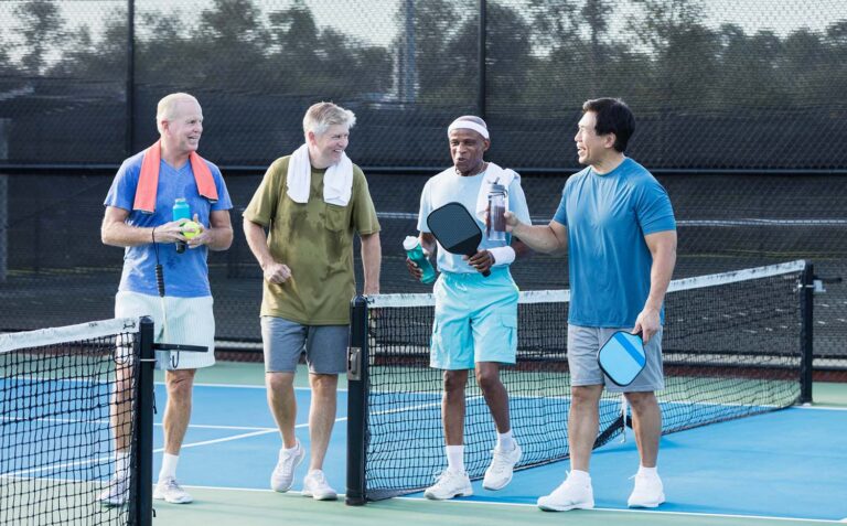 Active Senior Men Playing Pickleball on Outdoor Court