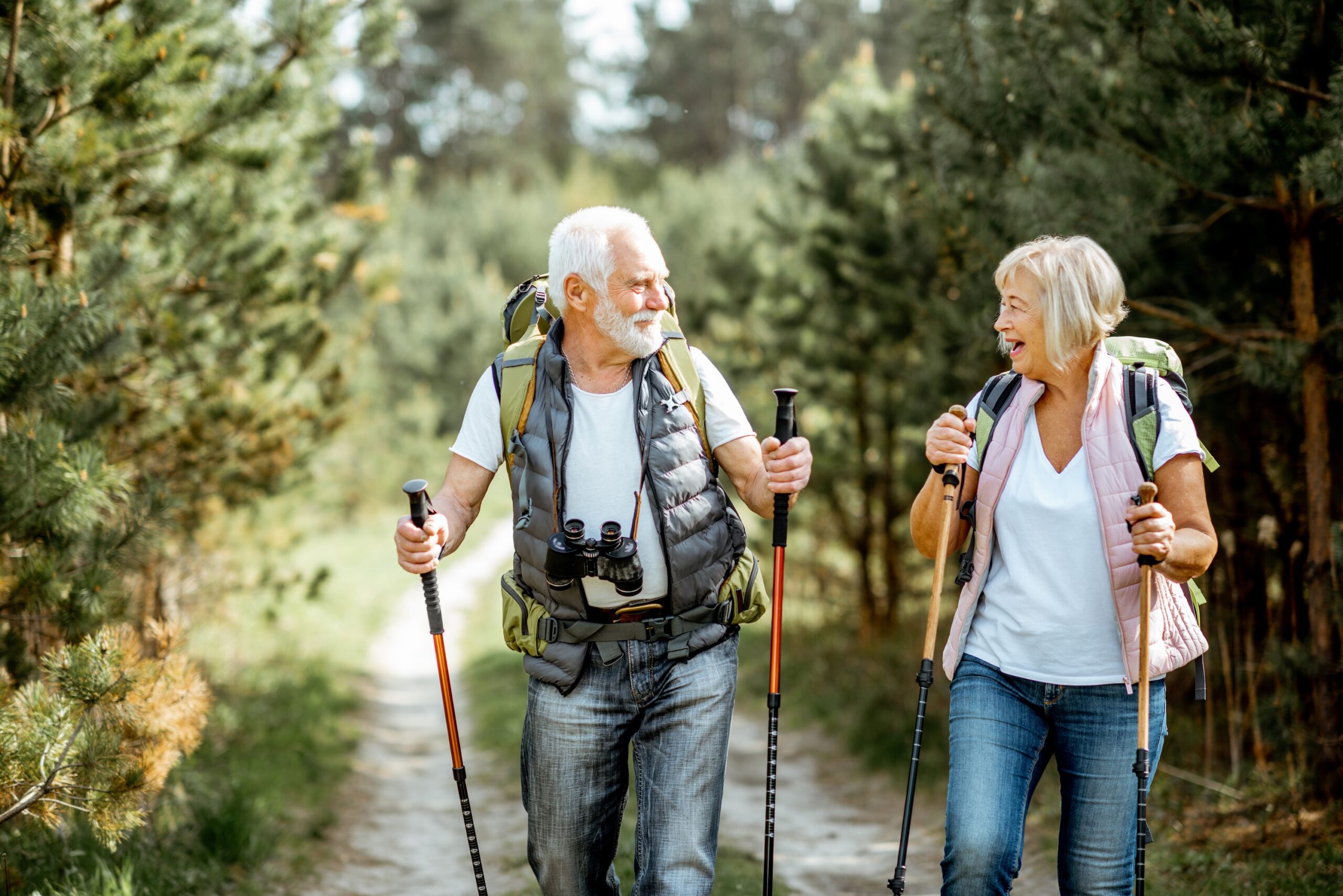 senior couple hiking forest trail scaled